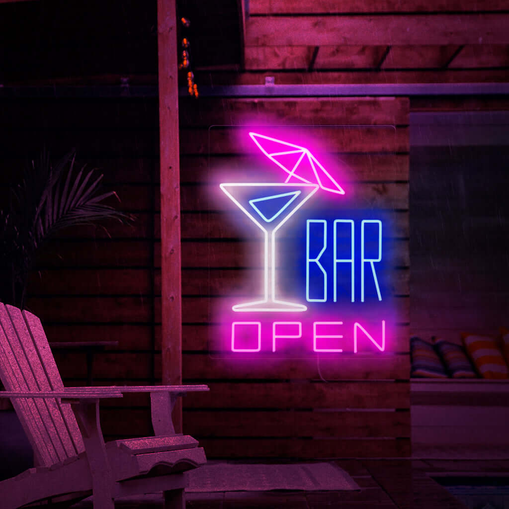 A foto mostra um letreiro de neon com um coquetel com guarda-chuva à esquerda e o texto "open bar" à direita. Este letreiro de neon é ideal para bares, tanto internos quanto externos.