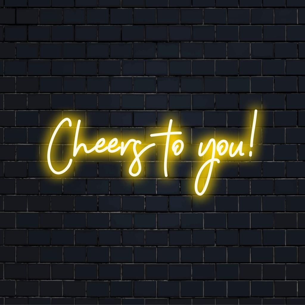 Display de neon vibrante "Cheers To You!", que mistura arte neon personalizada com iluminação LED vibrante para decoração festiva.