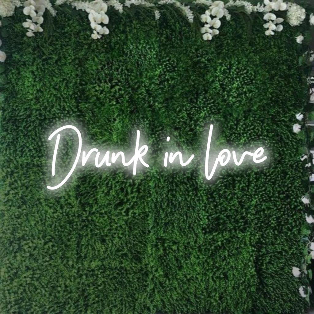 Placa de LED neon personalizada e vívida com os dizeres "Drunk In Love" (Bêbado de Amor), iluminando espaços com arte neon vibrante e ambiente brilhante.