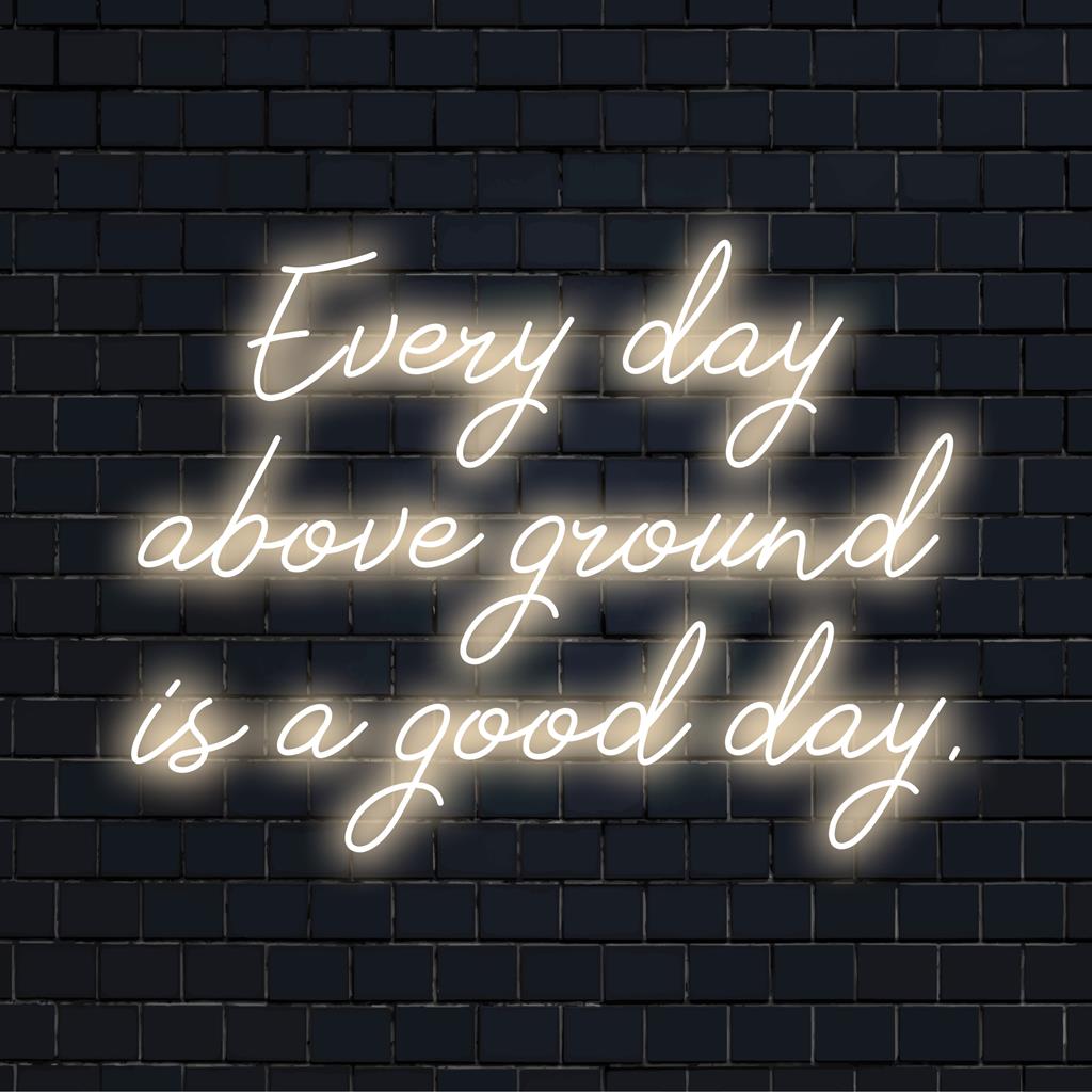 Placa de neon LED personalizada com os dizeres "Every Day Above Ground Is A Good Day" (Todo dia acima do solo é um bom dia), perfeita para decoração de parede neon exclusiva e vibrações positivas.