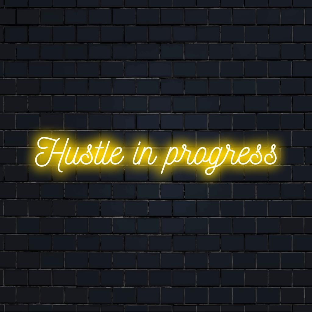 Placa de neon LED personalizada com os dizeres "Hustle In Progress", ideal para decoração motivacional em residências ou escritórios.