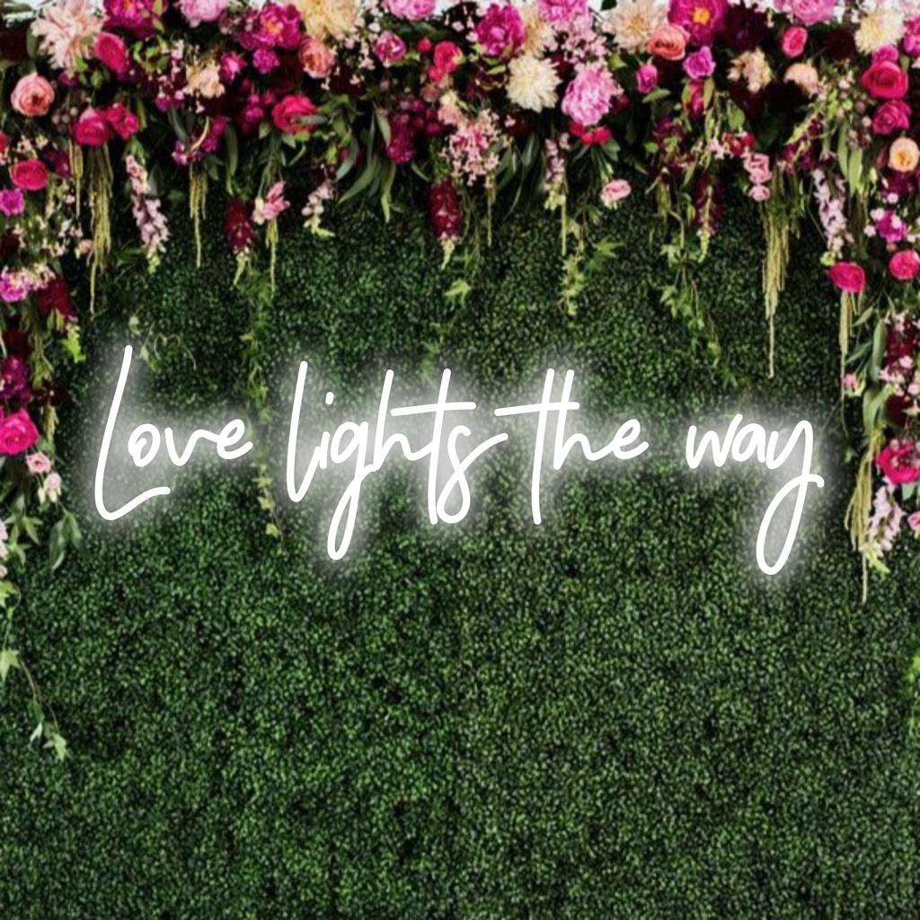 Placa de neon LED com a frase Love Lights The Way; combina arte de texto e brilho suave, ideal para inspirar e iluminar espaços.