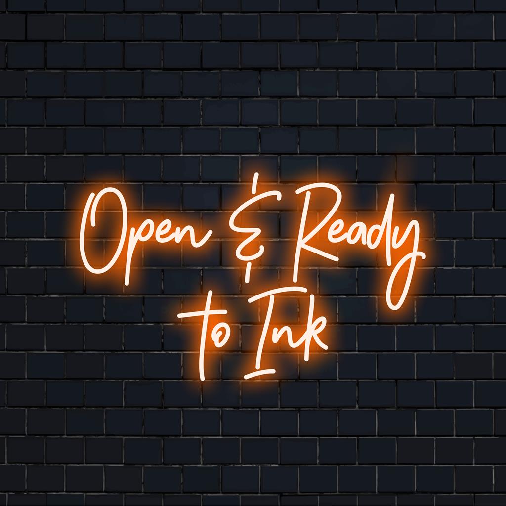 Placa de neon LED com a mensagem convidativa "Aberto, pronto para tatuar" em letras grandes e brilhantes, perfeita para estúdios de tatuagem ou quiosques.