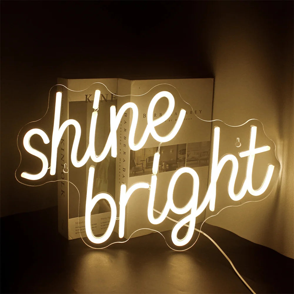 Uma vibrante placa de LED neon exibindo as palavras "Shine Bright" em uma fonte animada.