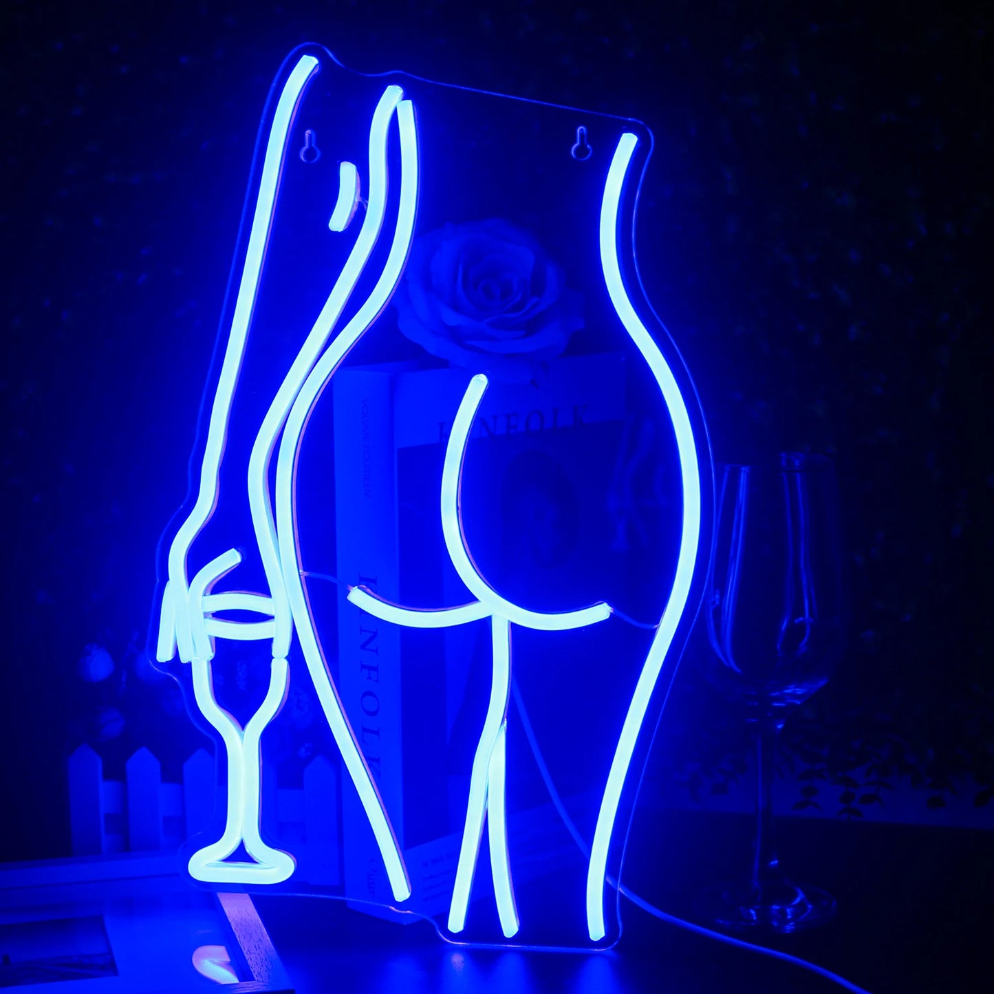 "Um letreiro de neon LED vibrante, feito à mão, no formato da silhueta de uma mulher reclinada.