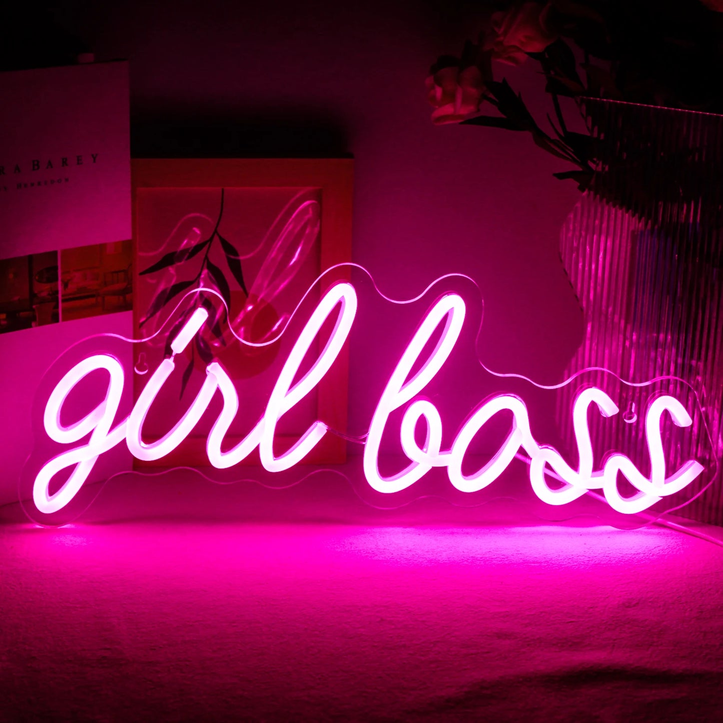 A imagem exibe uma vibrante placa de LED neon feita à mão que diz "Girl Boss" em uma fonte cursiva e estilosa.