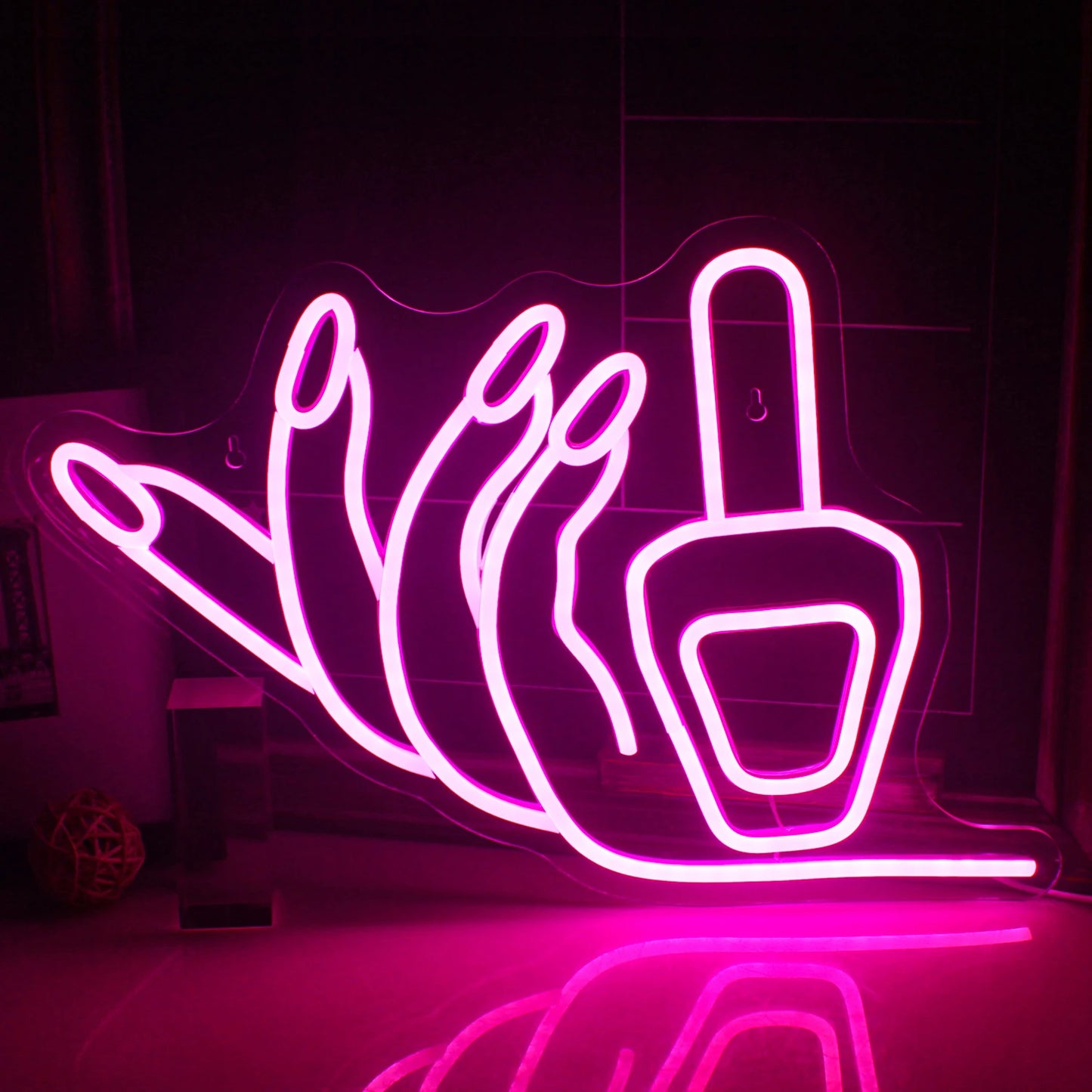 A imagem apresenta um letreiro de LED neon vibrante, feito à mão, no formato de um prego, brilhando em rosa brilhante.
