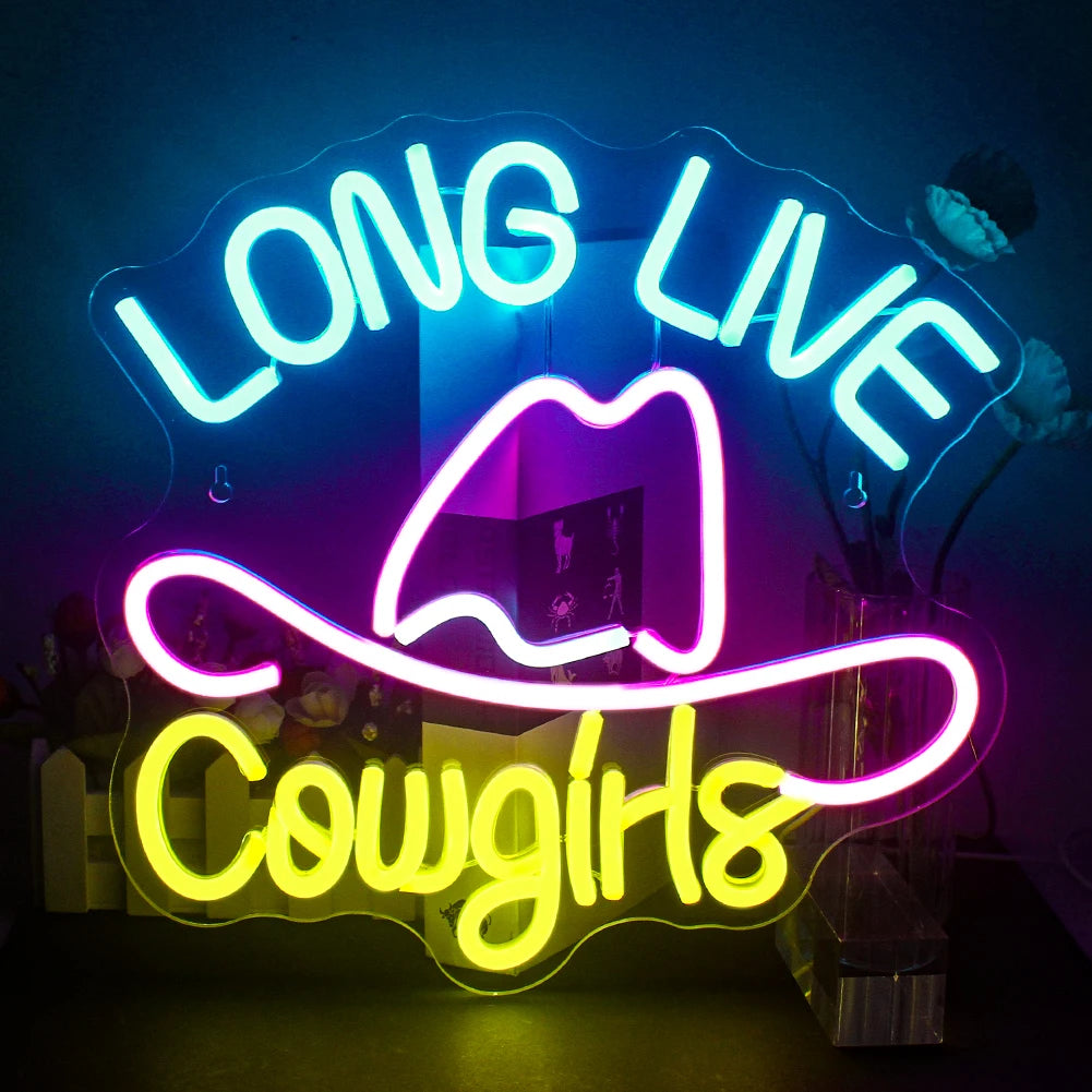 Uma vibrante placa de LED neon exibindo as palavras "Vida Longa às Cowgirls" em uma escrita cursiva em negrito.