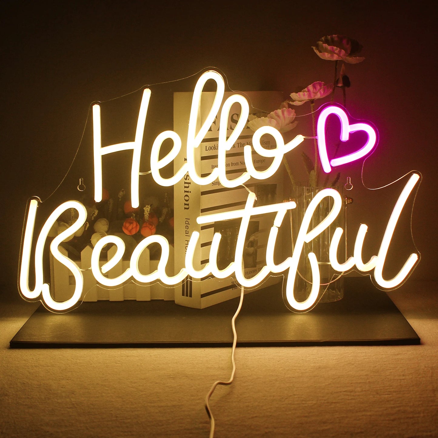 A imagem mostra uma vibrante placa de LED neon feita à mão que diz "Hello Beautiful" em uma fonte cursiva divertida.