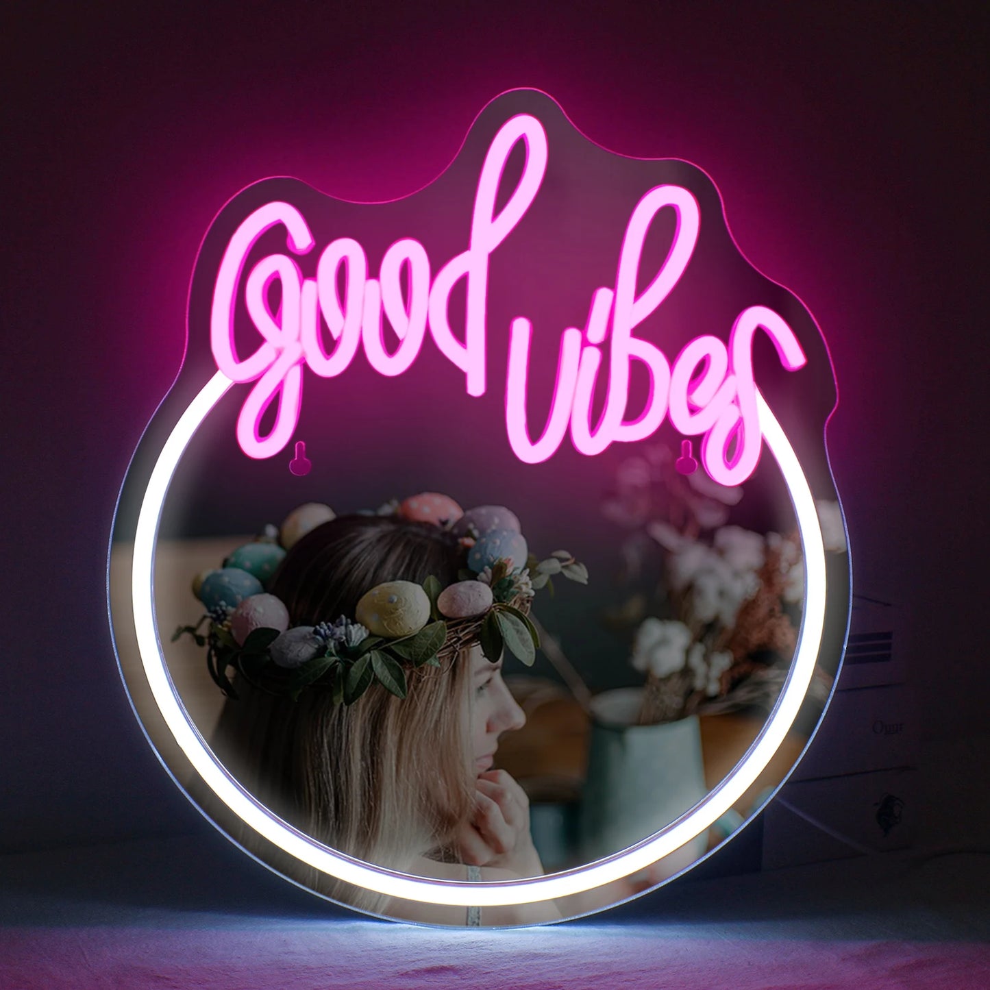 A imagem exibe uma elegante placa de LED neon que diz "Good Vibes" em letras rosa vibrantes e brilhantes.
