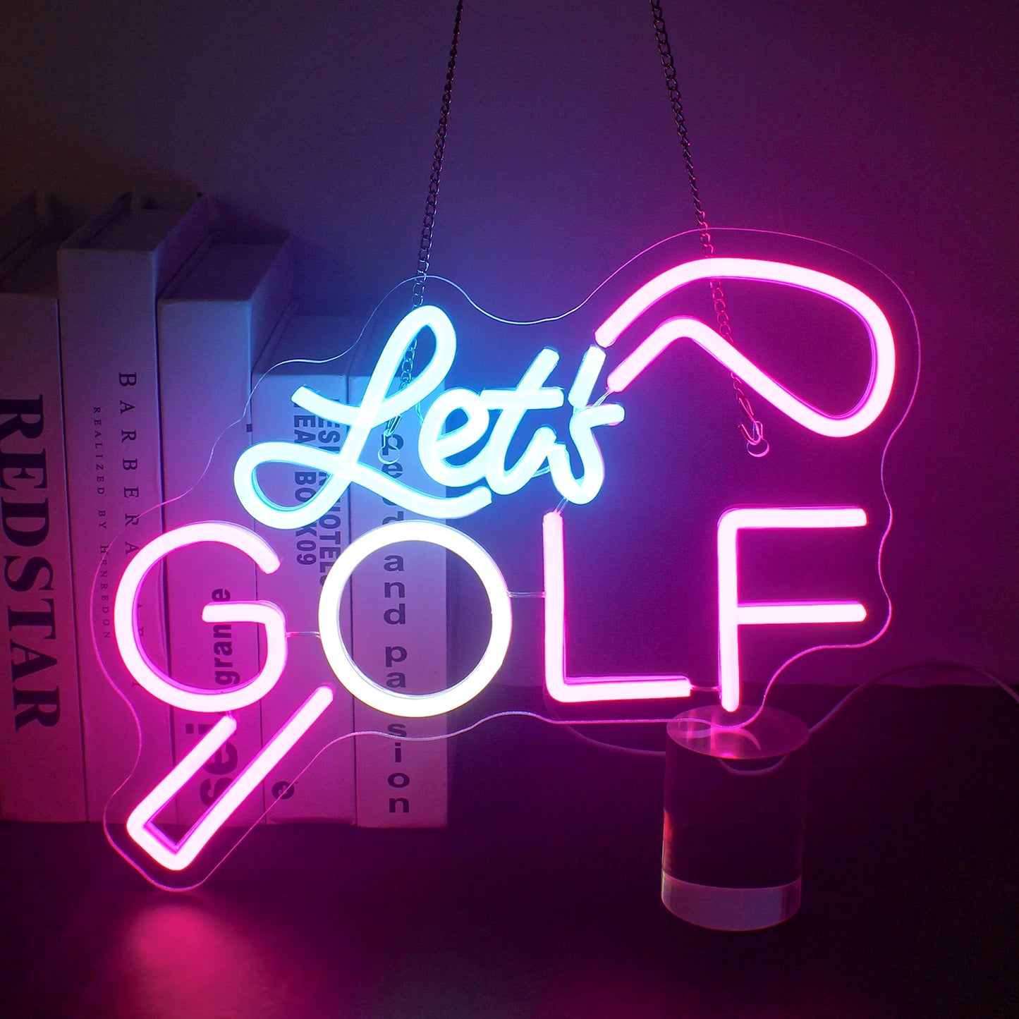 Uma vibrante placa de LED neon exibindo as palavras "Let's Golf" em cores verde e branco brilhantes.