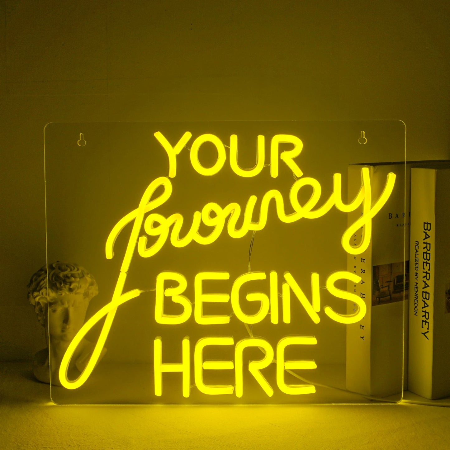 "Uma placa de LED neon feita à mão exibindo as palavras 'Journey Begin' em uma fonte fluida.