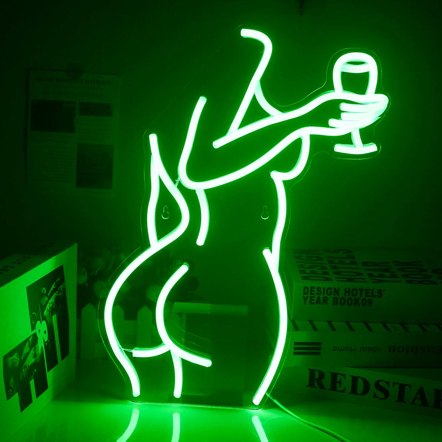 A imagem apresenta um letreiro de LED neon vibrante representando o contorno de uma mulher elegantemente vestida segurando uma taça de vinho.