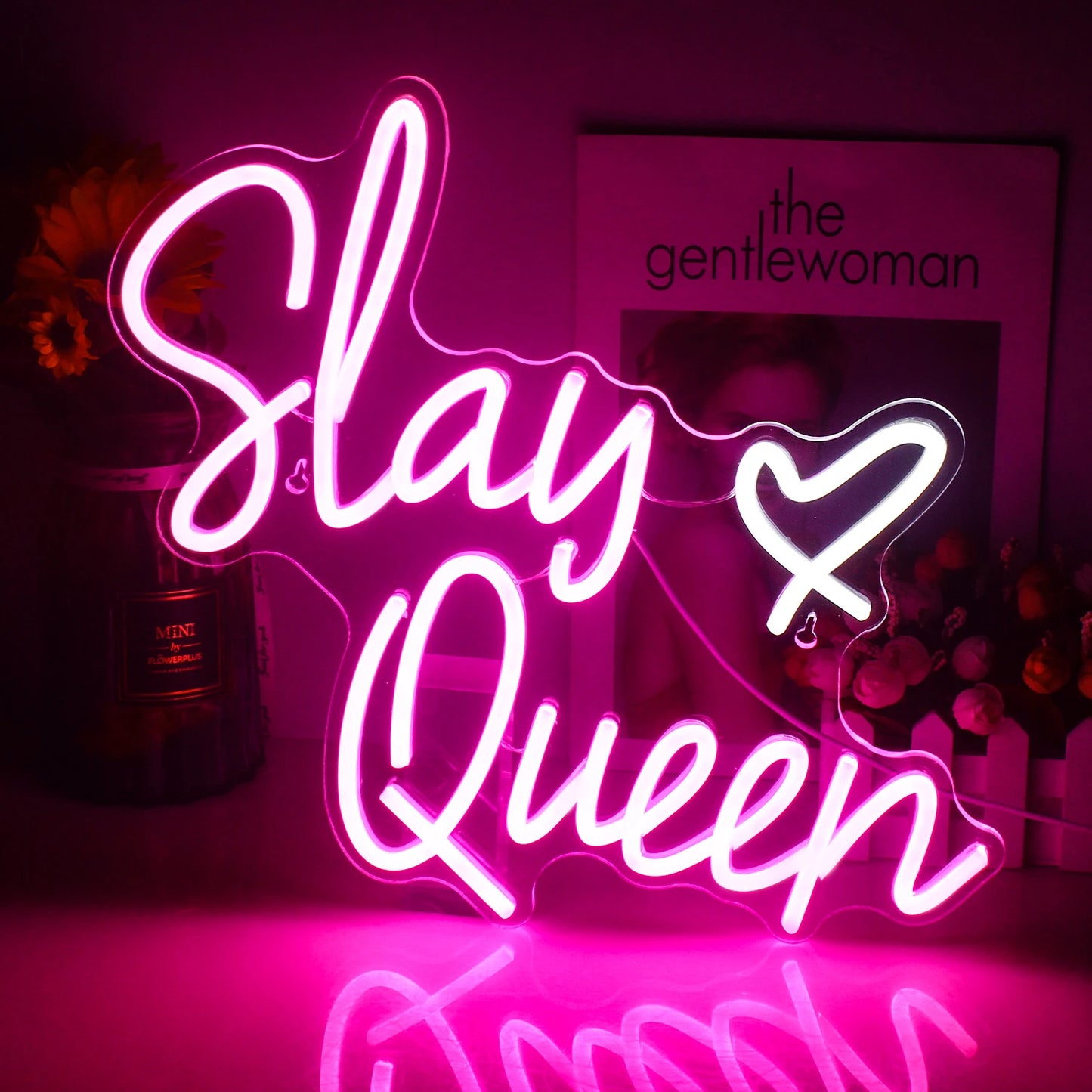 A imagem apresenta um letreiro de LED neon vibrante exibindo as palavras "Slay Queen" em letras cursivas elegantes.