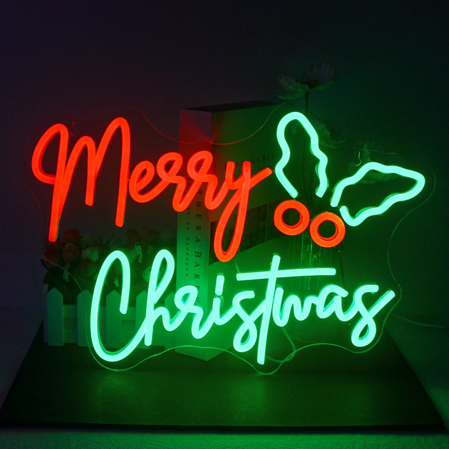 Uma vibrante placa de LED neon com os dizeres "Feliz Natal" é exibida sobre um fundo escuro.