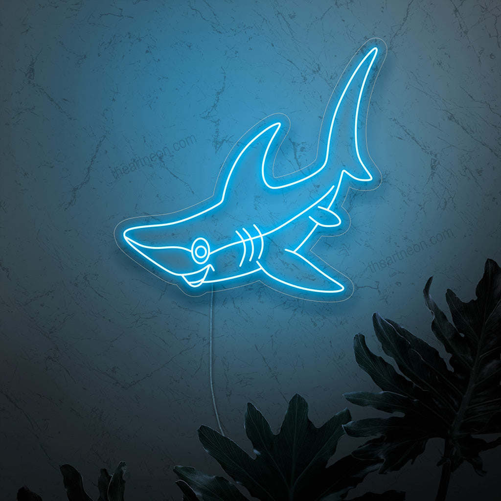Um letreiro de neon em forma de tubarão sorridente, irradiando um brilho vibrante e hipnotizante, acrescentando um charme lúdico e uma presença eletrizante a qualquer espaço.