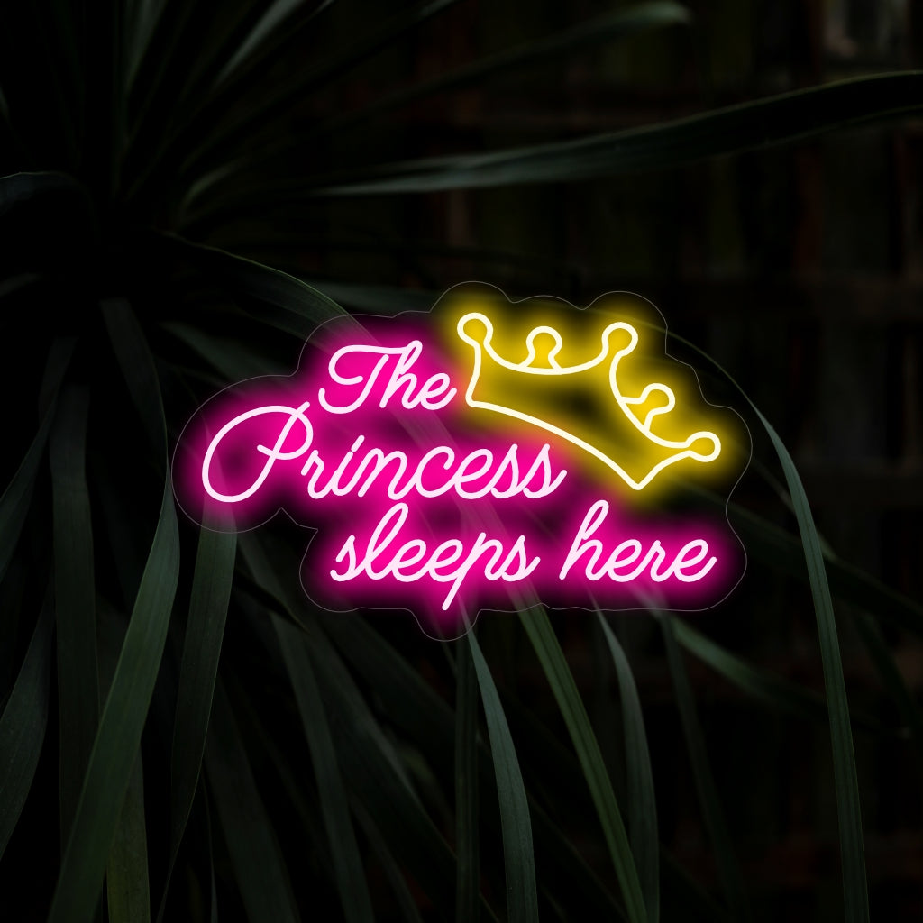 O letreiro de neon "A Princesa Dorme Aqui" encanta com sua charmosa proclamação, lançando um brilho suave que acrescenta magia de conto de fadas ao seu espaço.