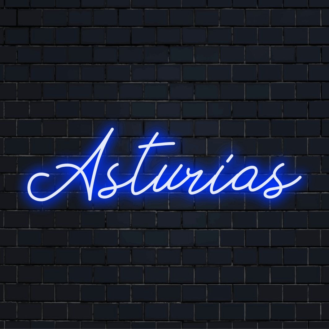 Asturias Neon Light with bright neon lettering against brick backdrop