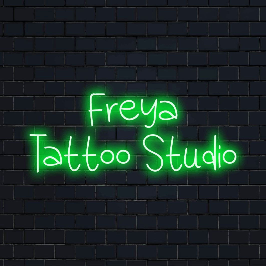 Freya Tattoo Studio Personalized Neon Light with bright neon lettering on black brick background