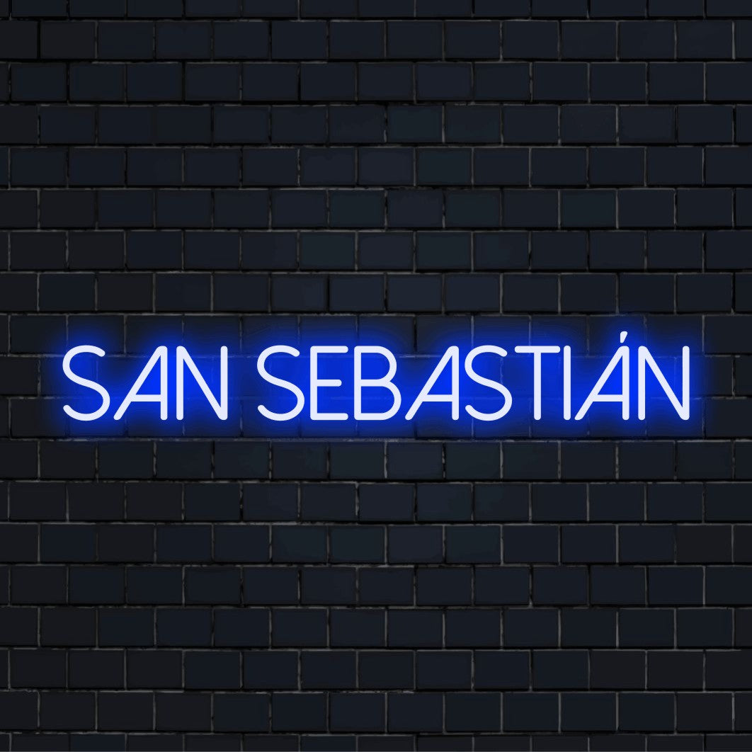 San Sebasti N Neon Sign, bright neon glow against black brick wall