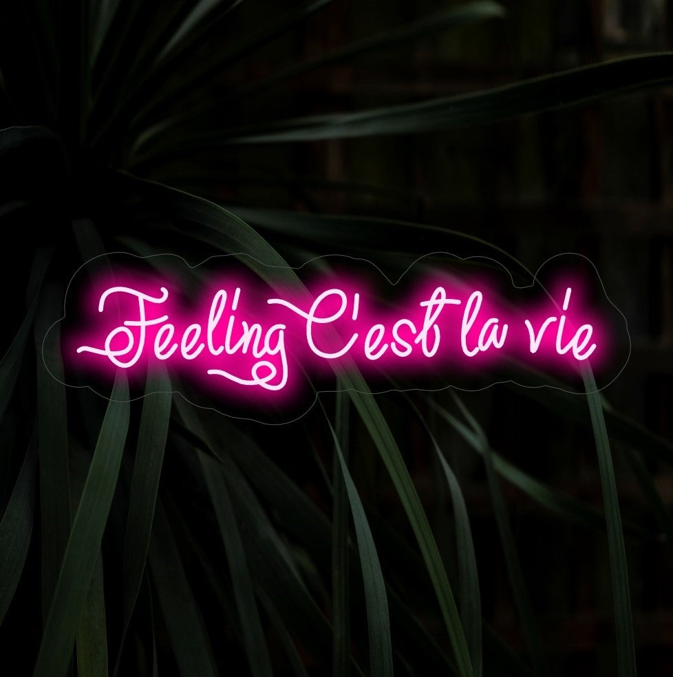 O letreiro de néon "Feeling C'est La Vie" acende com um brilho despreocupado, ideal para espaços que adotam a atitude lúdica de viver a vida ao máximo com um toque de estilo francês.