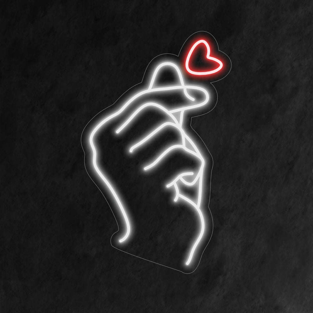 O letreiro de neon em forma de coração no dedo acende com amor, perfeito para espaços que abraçam a positividade e o gesto reconfortante do coração no dedo, adicionando um toque fofo ao ambiente.