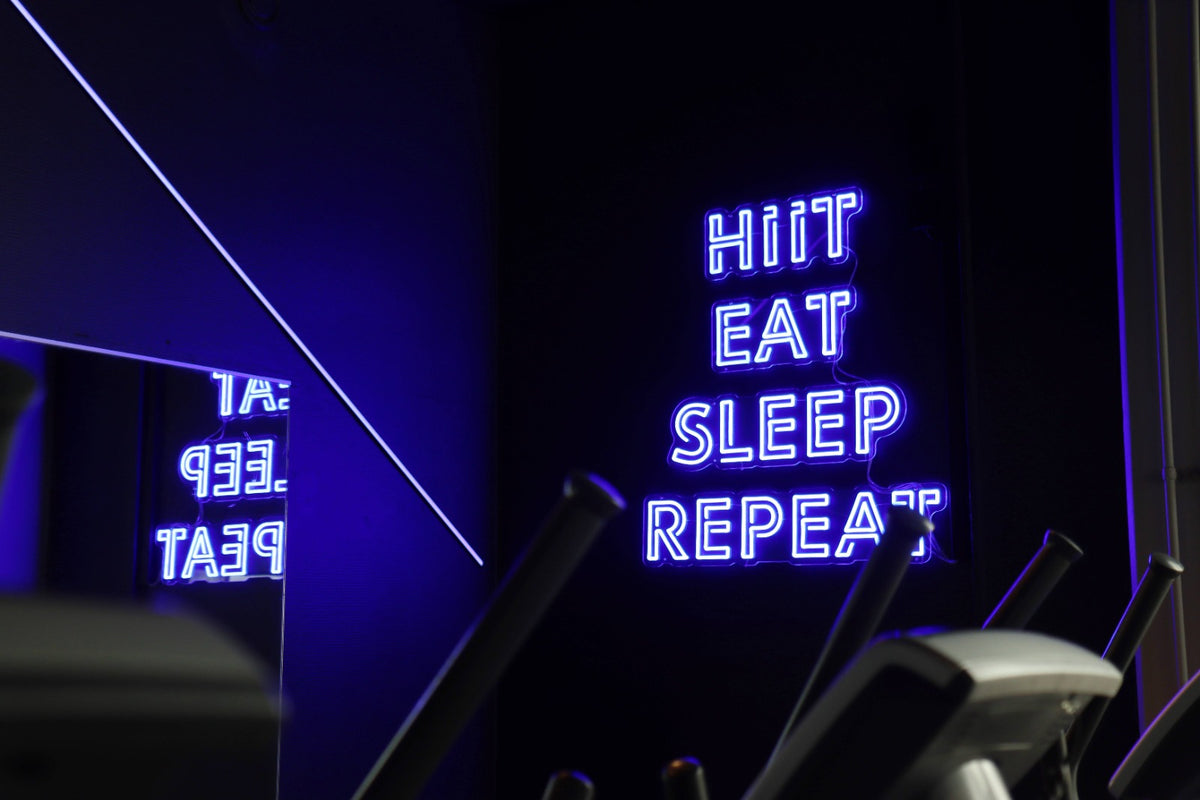 Four blue LED neon word signs installed in a gym