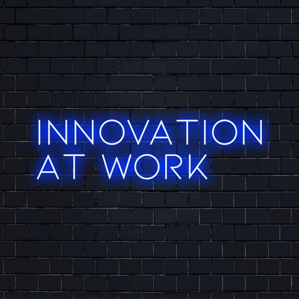 Placa de LED neon personalizada com a frase Innovation At Work, brilhando em cores vibrantes, perfeita para decoração de escritório moderna.