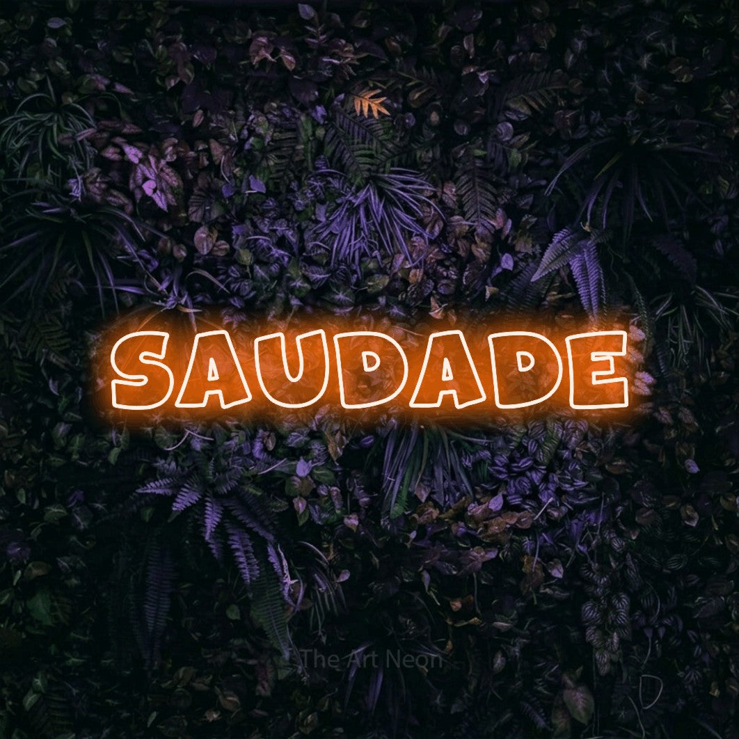 LED neon sign reading “SAUDADE”, arranged in a single line.