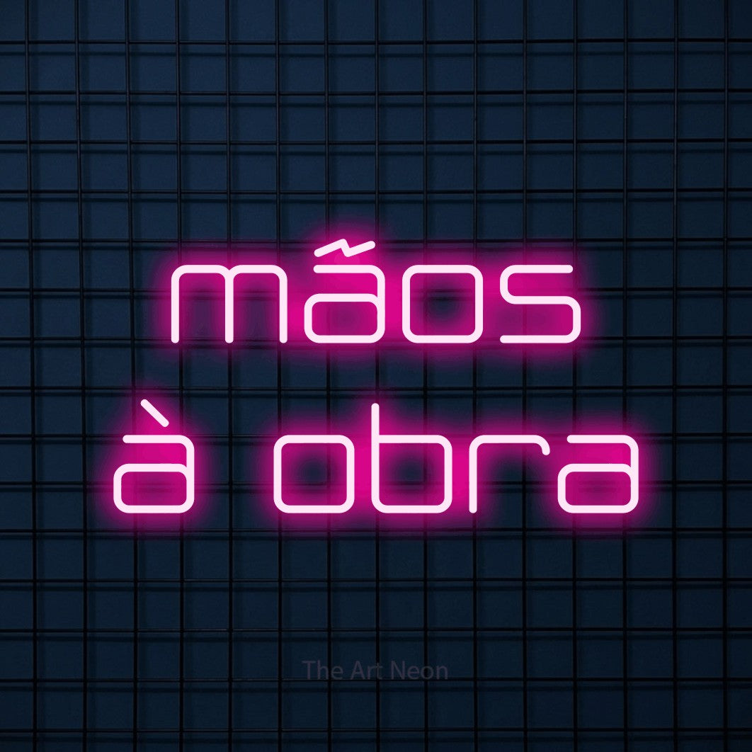 LED neon sign reading “mãos à obra”, arranged in 2 lines.