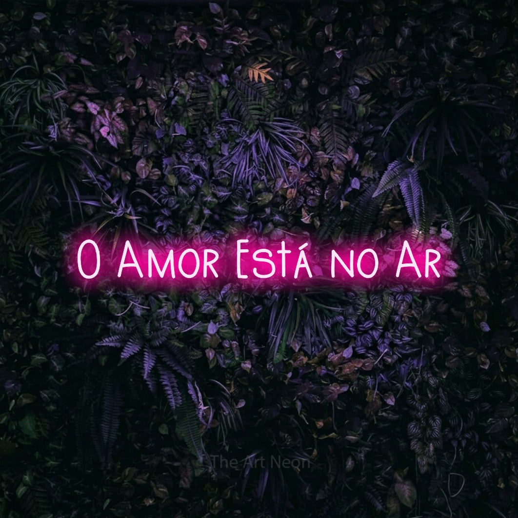 LED neon sign reading “O Amor Está no Ar”, arranged in a single line.