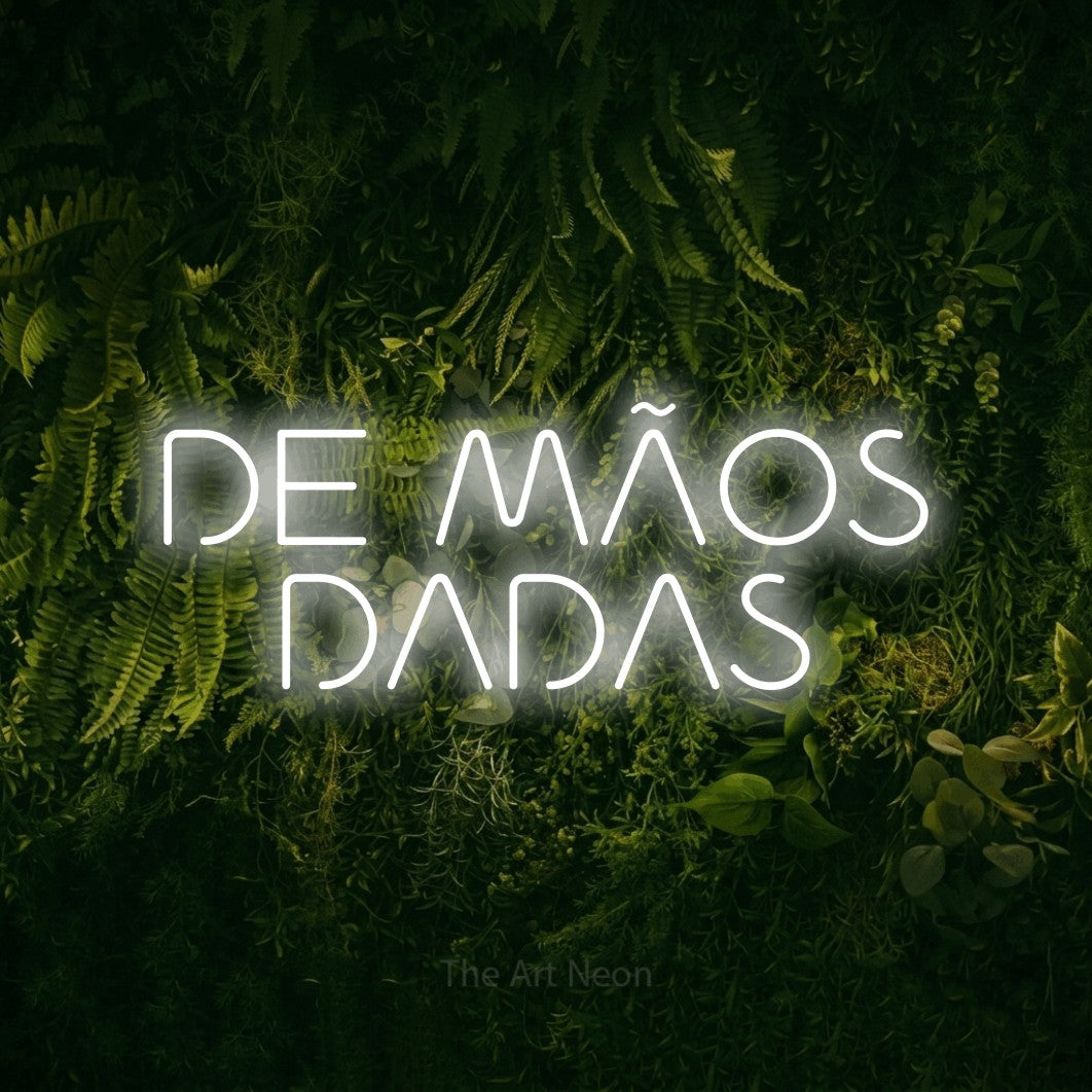 LED neon sign reading “DE MÃOS DADAS”, arranged in 2 lines.