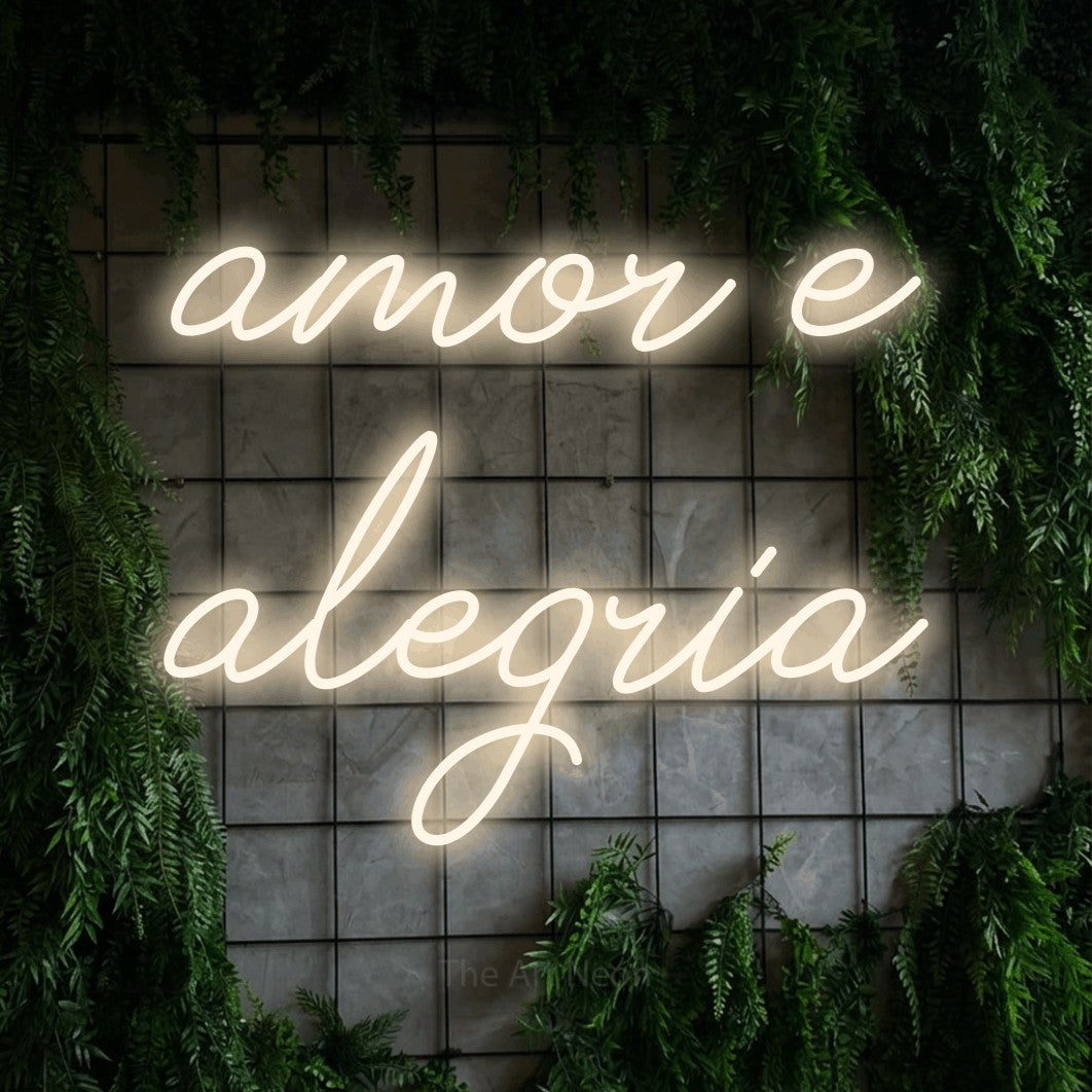 LED neon sign reading “amor e alegria”, arranged in 2 lines.