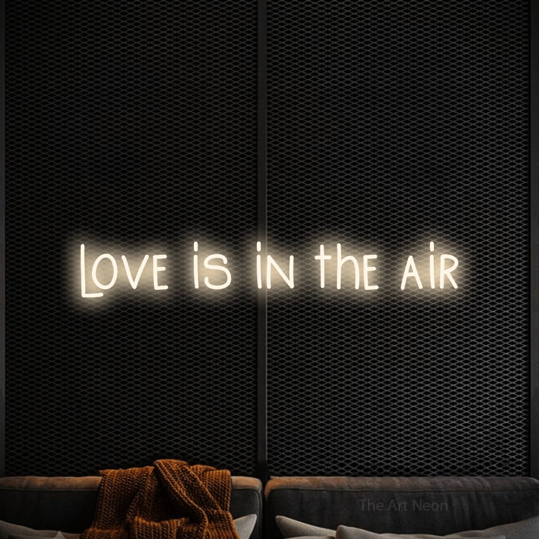 LED neon sign reading “love is in the air”, arranged in a single line.