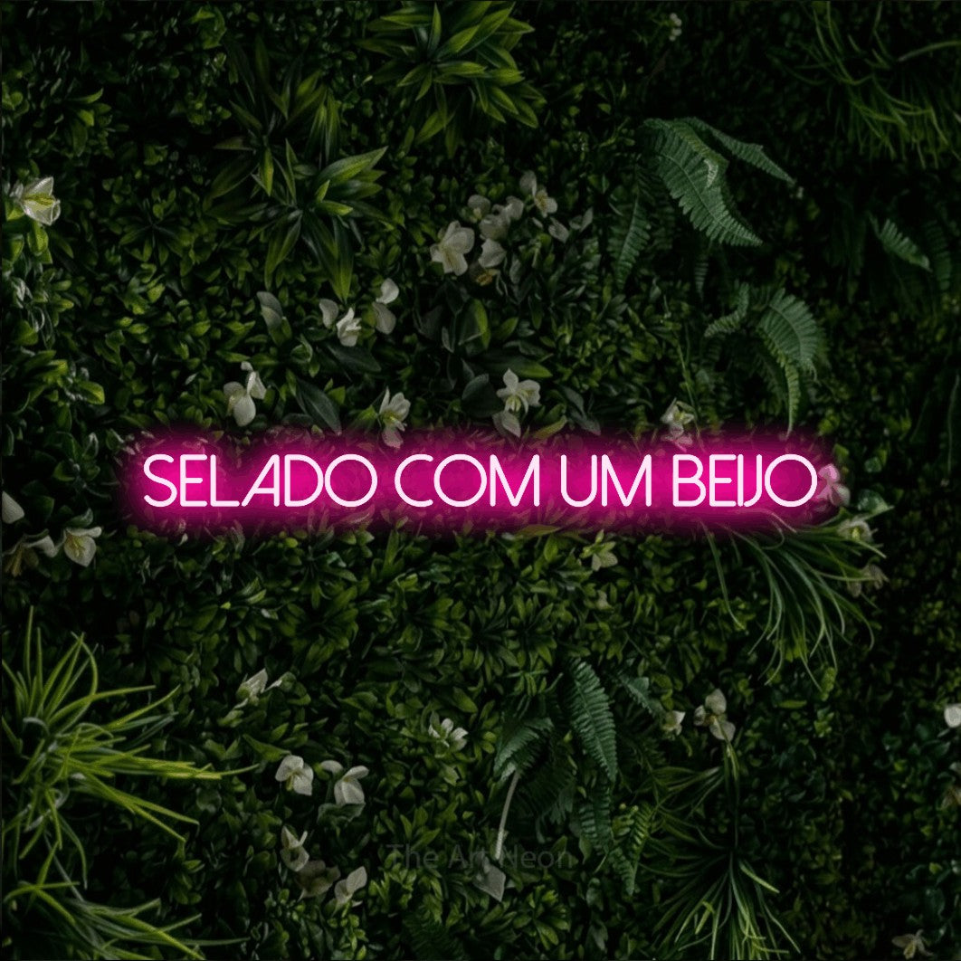 LED neon sign reading “Selado com Um Beijo”, arranged in a single line.