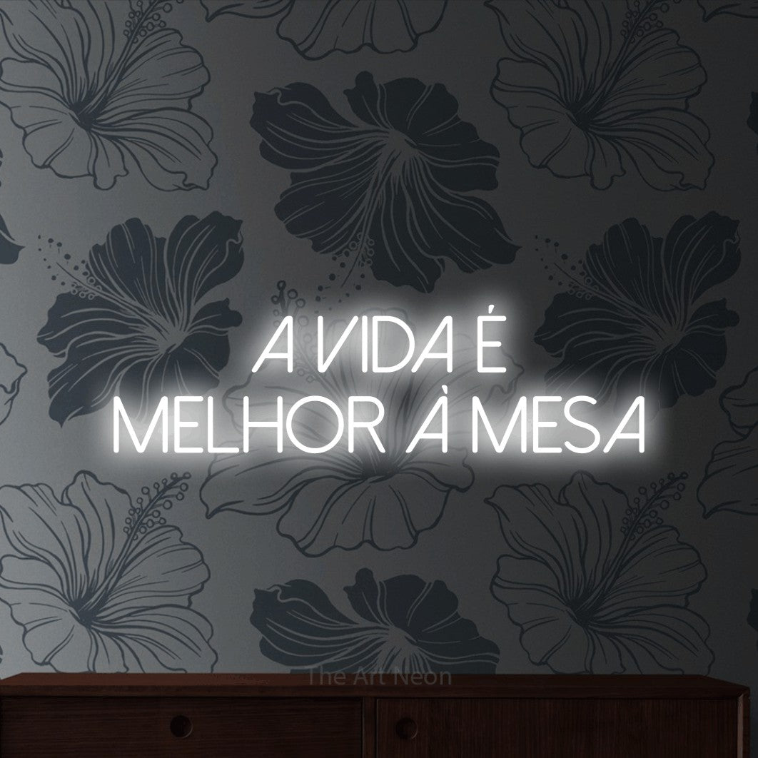 LED neon sign reading “a vida é melhor à mesa”, arranged in 2 lines.