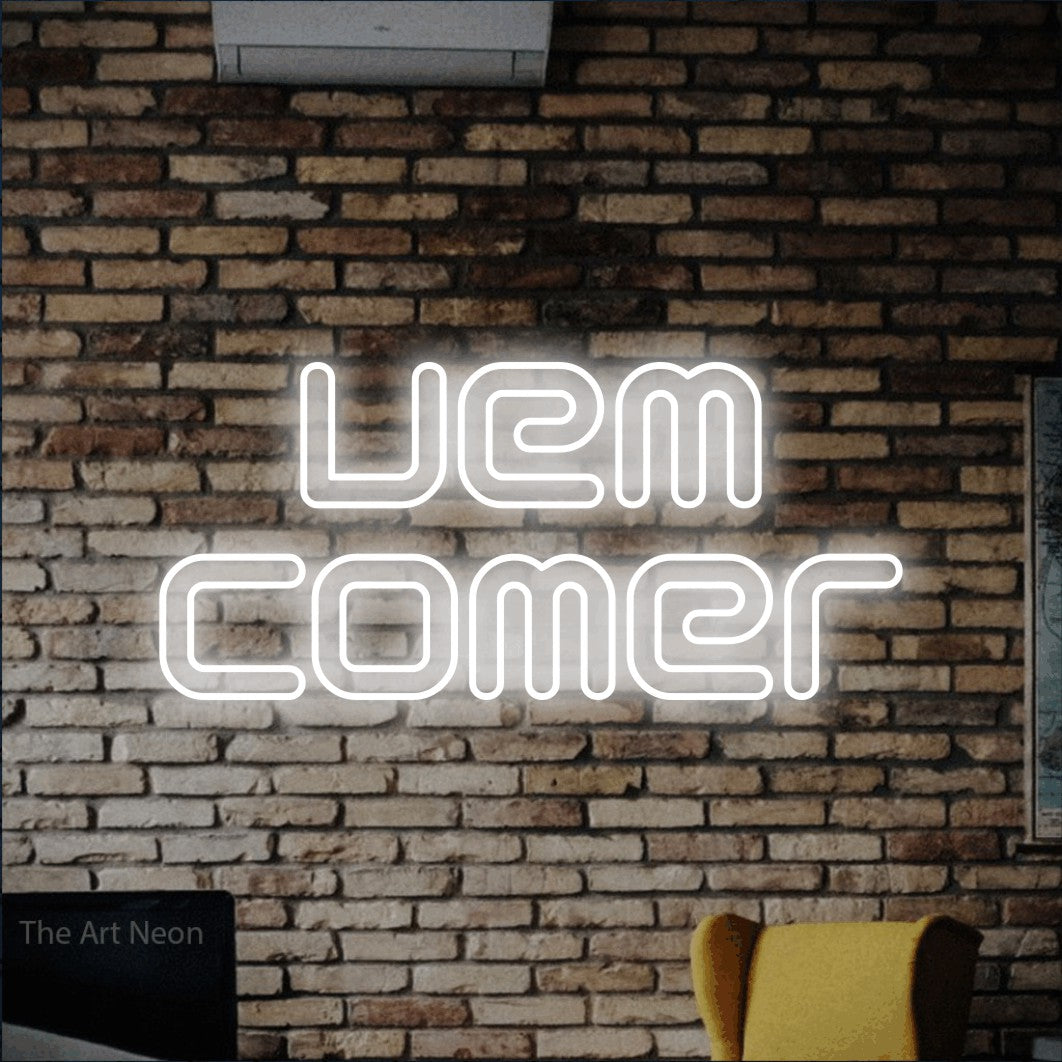 LED neon sign reading “vem comer”, arranged in 2 lines.