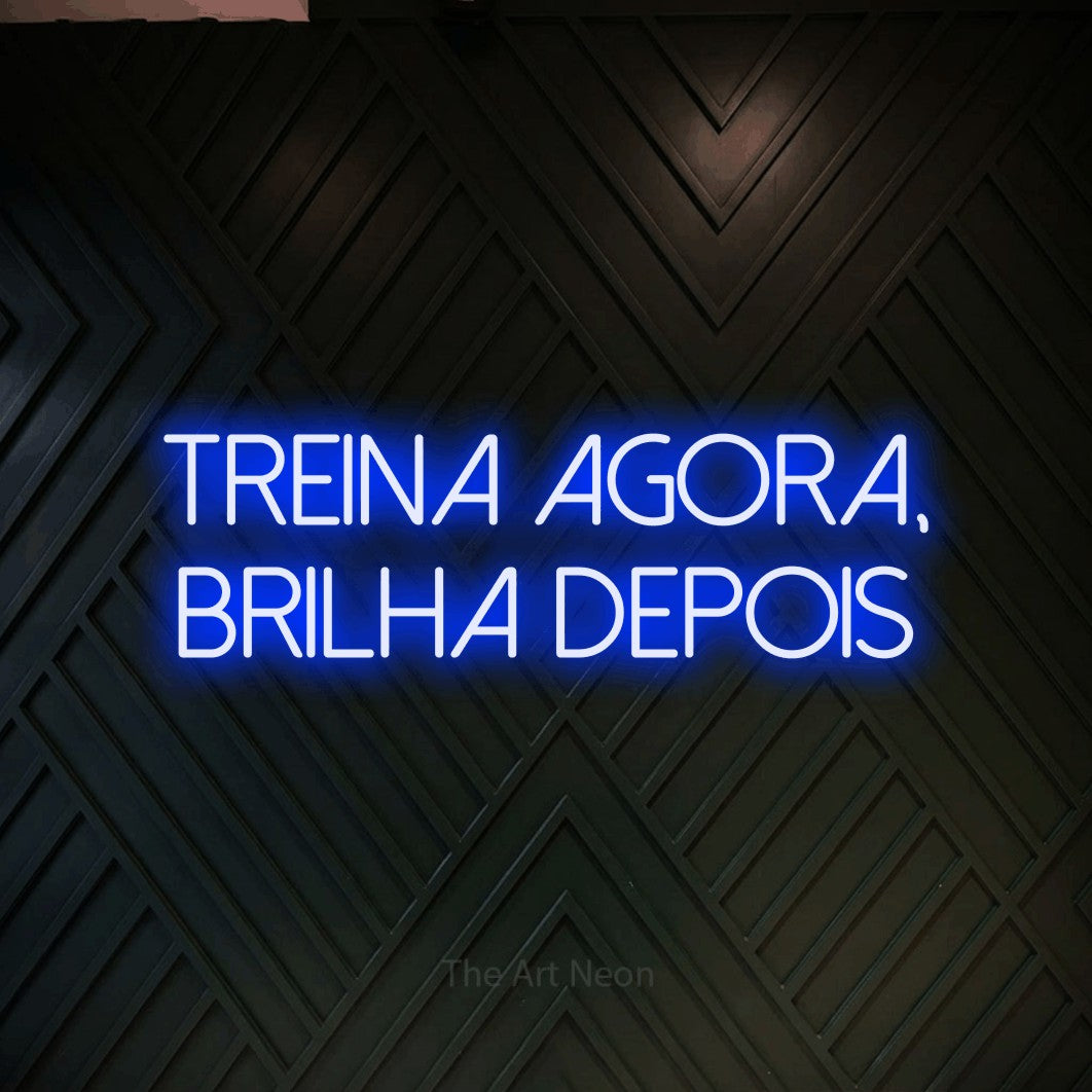 LED neon sign reading “treina agora, brilha depois”, arranged in 2 lines.