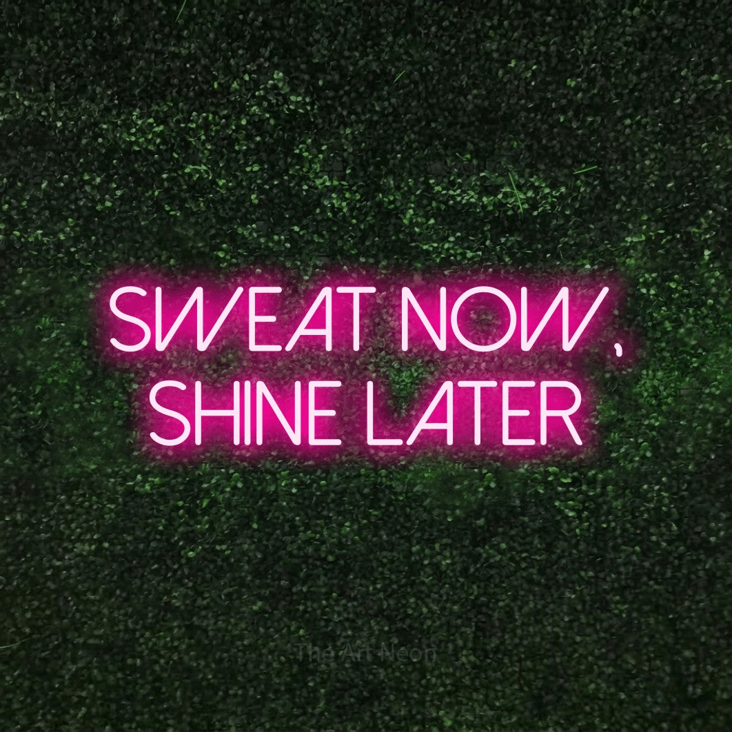 LED neon sign reading “sweat now, shine later”, arranged in 2 lines.