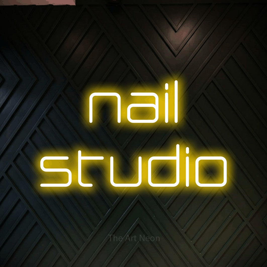 LED neon sign reading “nail studio”, arranged in 2 lines.