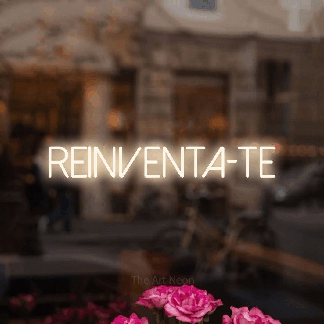 LED neon sign reading “REINVENTA-TE”, arranged in a single line.