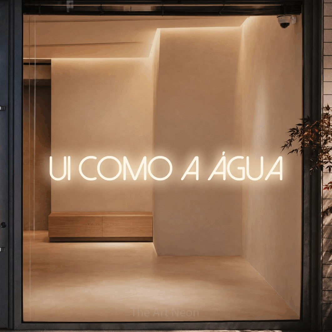 LED neon sign reading “flui como a água”, arranged in a single line.