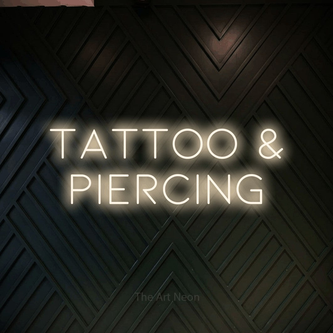 LED neon sign reading “tattoo & PIERCING”, arranged in 2 lines.