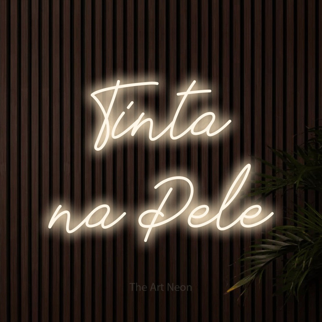 LED neon sign reading “Tinta na Pele”, arranged in 2 lines.