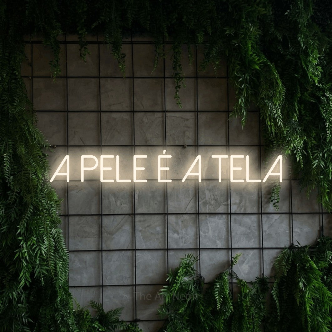 LED neon sign reading “A PELE É A TELA”, arranged in a single line.