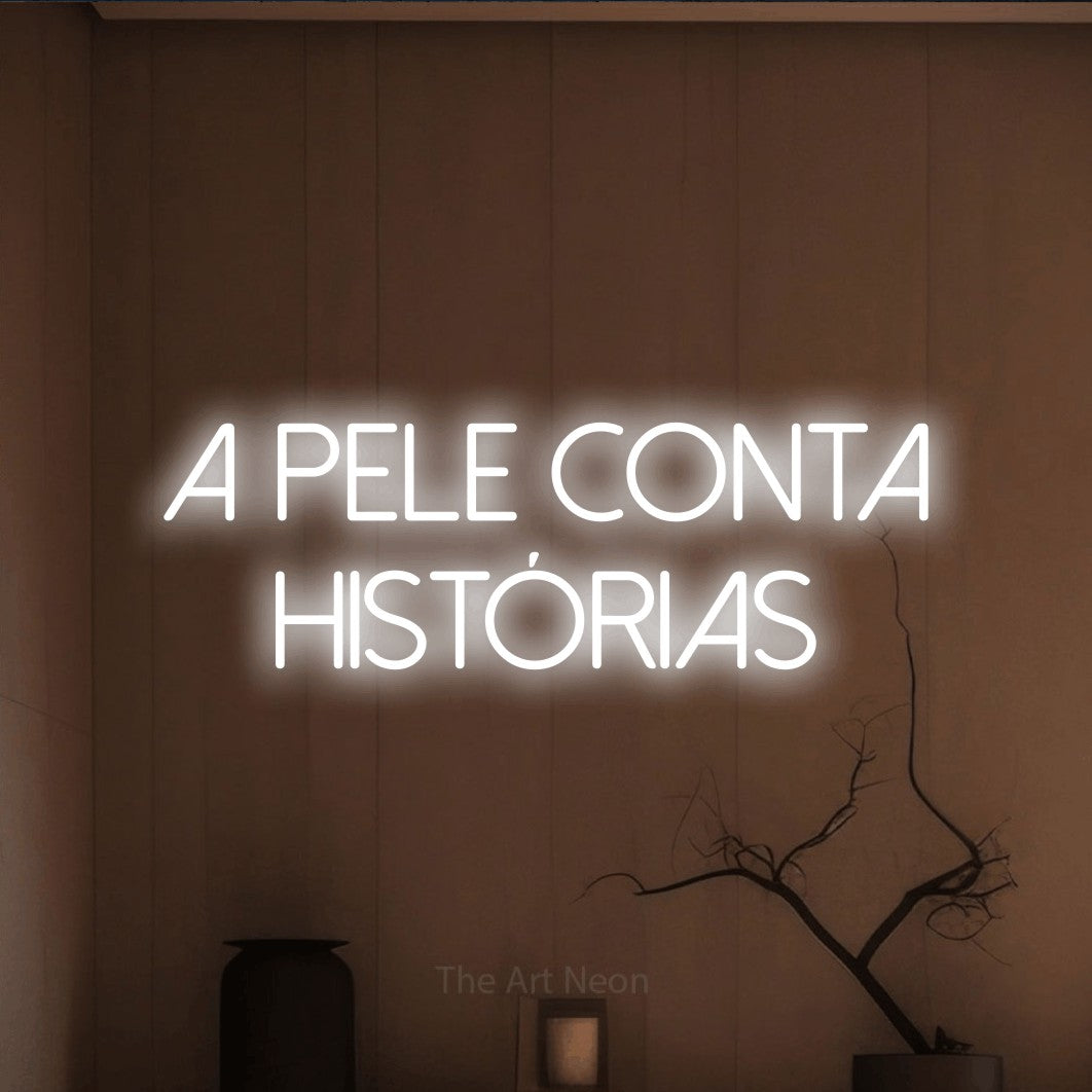 LED neon sign reading “a pele conta histórias”, arranged in 2 lines.