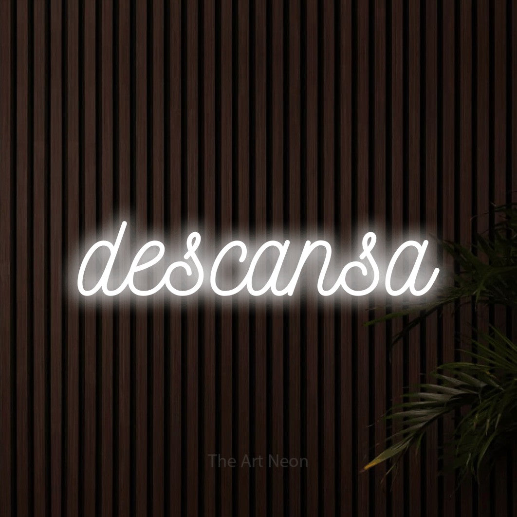 LED neon sign reading “descansa”, arranged in a single line.