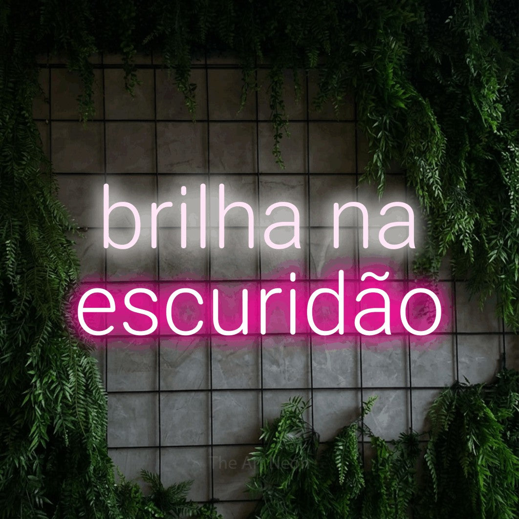 LED neon sign reading “brilha na escuridão”, arranged in 2 lines.