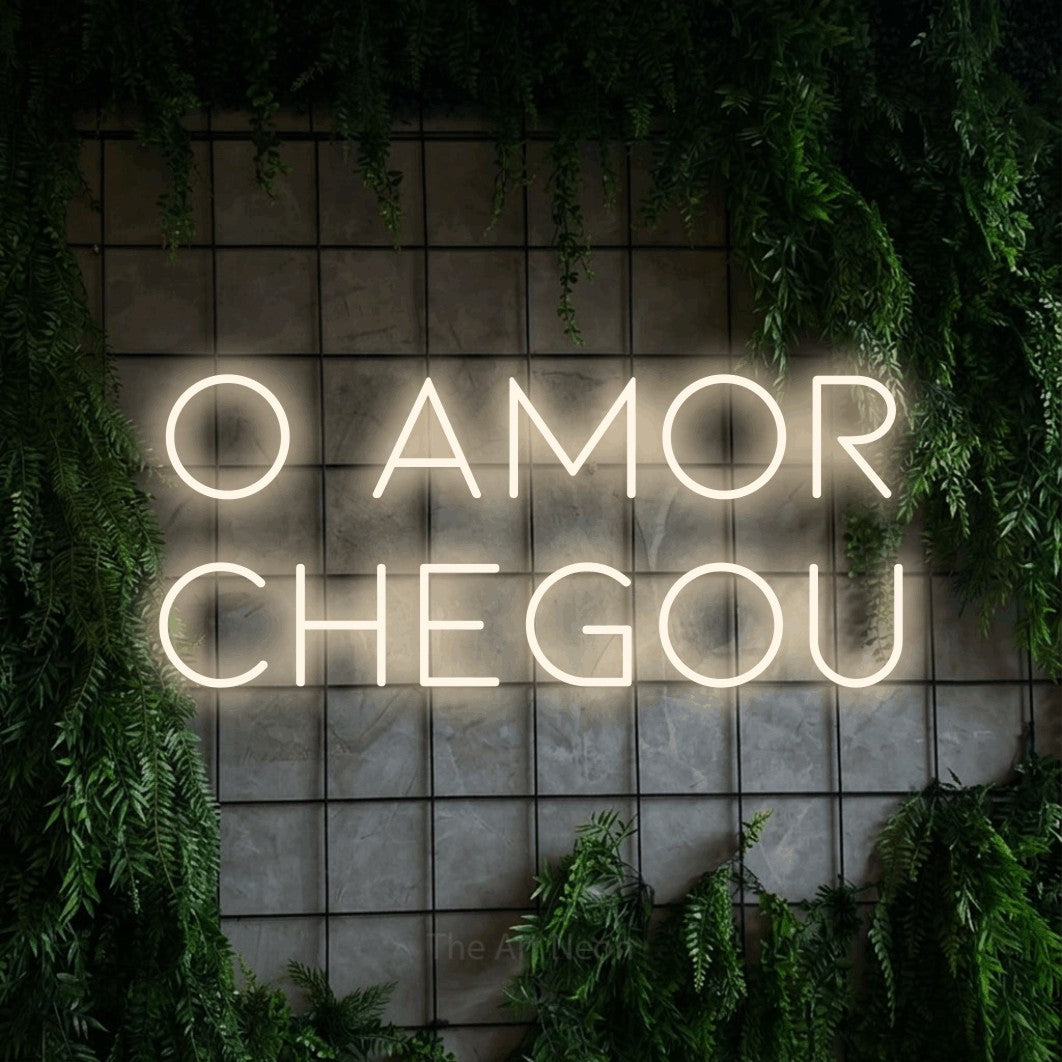 LED neon sign reading “O amor chegou”, arranged in 2 lines.