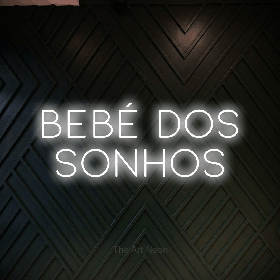 LED neon sign reading “bebé dos sonhos”, arranged in 2 lines.